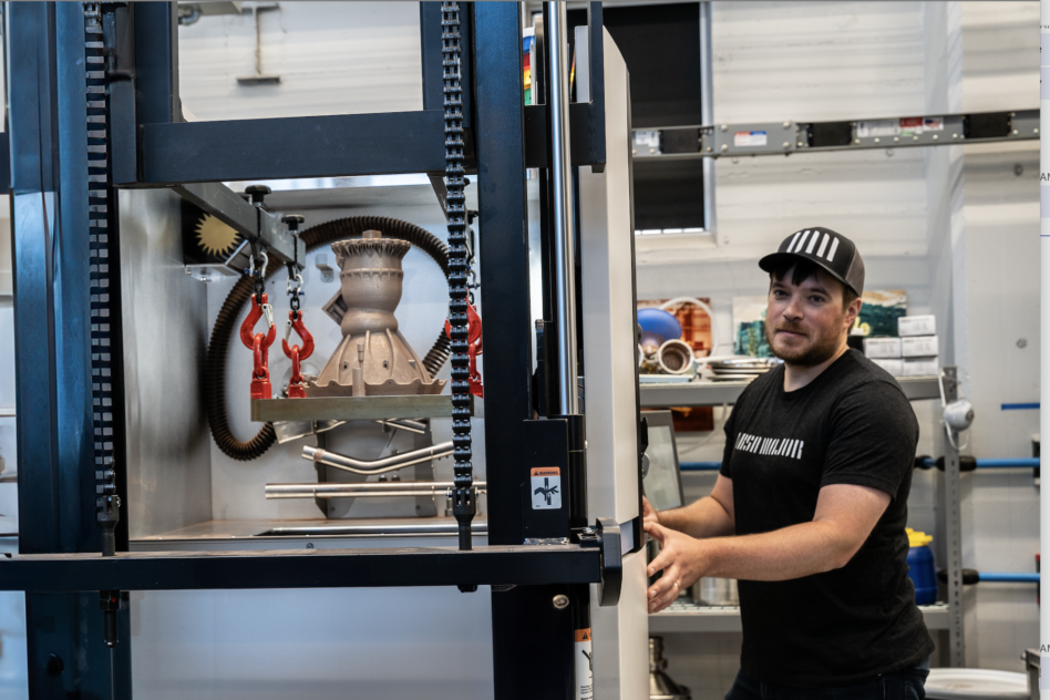 Ursa Major's Thomas Pomorski prepares one of its Hadley engine chambers for transport after 3-D printing is complete. Image: Ursa Major.