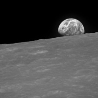 The Earth rising is about five degrees above the lunar horizon in this black and white telephoto view photographed from the Apollo 8 spacecraft near 110 degrees east longitude. The horizon, about 570 kilometers (350 statute miles) from the spacecraft, is near the eastern limb of the Moon as viewed from Earth. On Earth, 240,000 statute miles away, the sunset terminator crosses Africa. The South Pole is in the white area near the left end of the terminator. North and South America are under clouds.