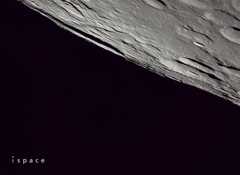 A dark background with a close up of gray lunar craters in the upper right hand corner and the ISpace logo in the lower left